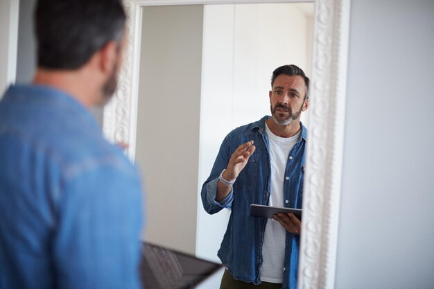 A man standing in front of mirror practicing speaking english